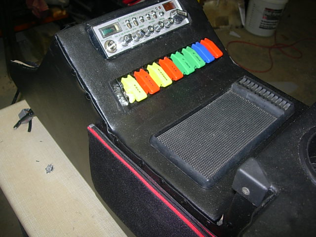 Custom vehicle center console with CB radio and toggle switches.
