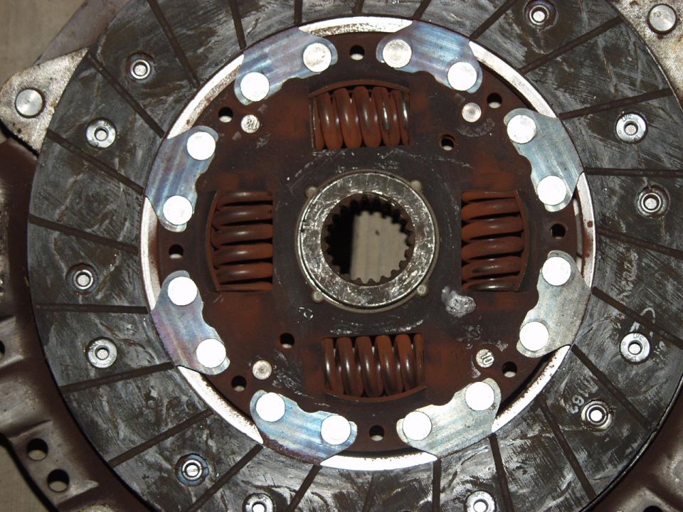 Close-up of a rusty clutch disc assembly with springs and a splined hub.