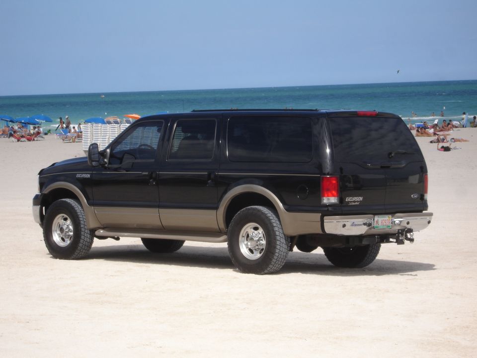 Black Ford Excursion Eddie Bauer SUV parked on a sandy beach