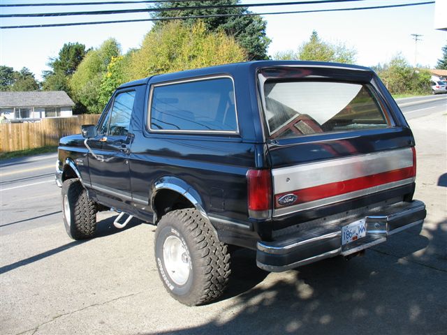 Dark blue 1988 Ford Bronco rear passenger side view with off-road tires
