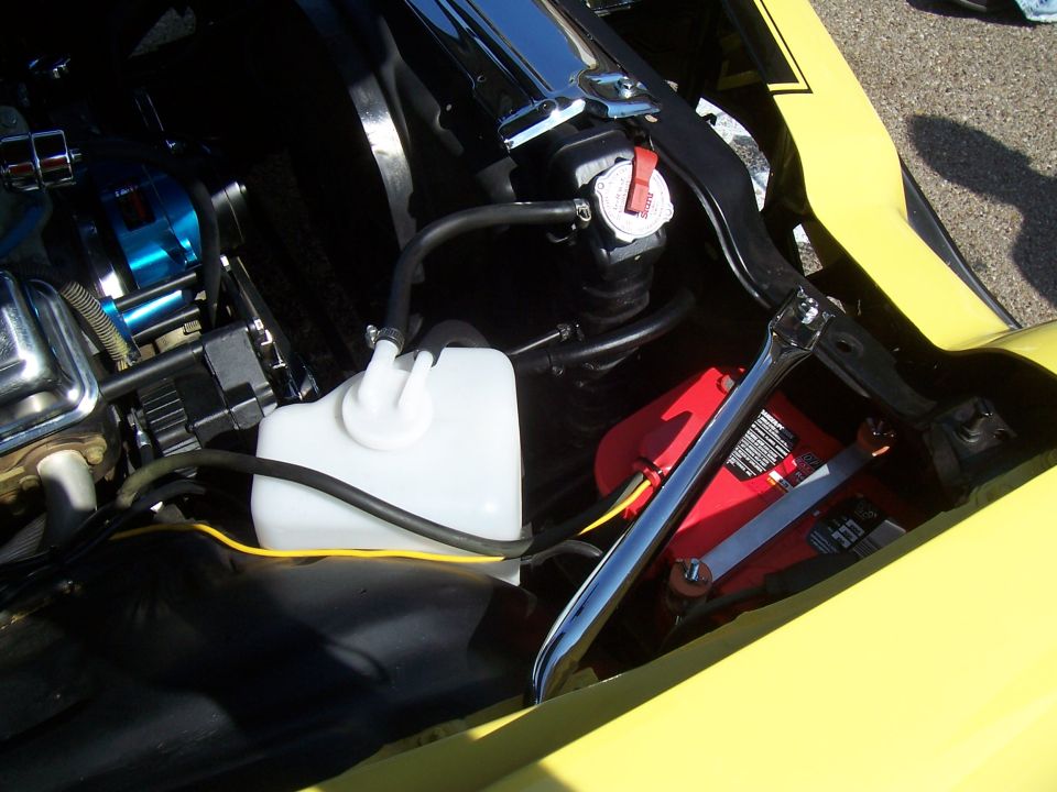 Photo of engine bay detail with coolant reservoir and battery