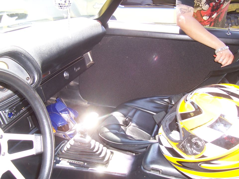 Photo of a car interior with shifter, seats and racing helmet