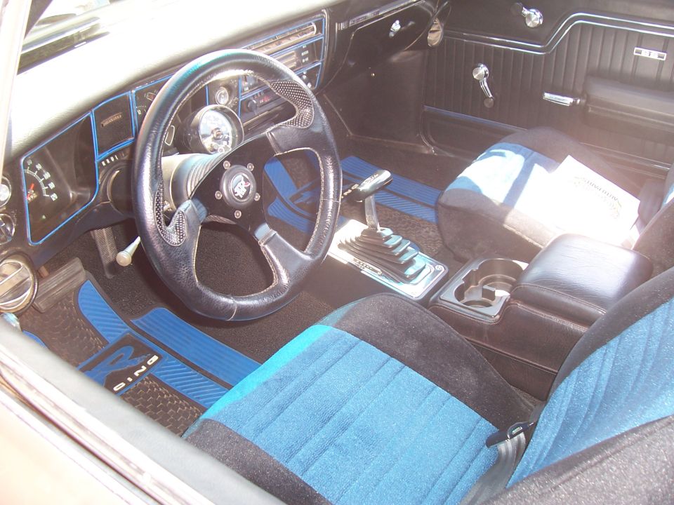 Photo of a blue and black car interior with steering wheel