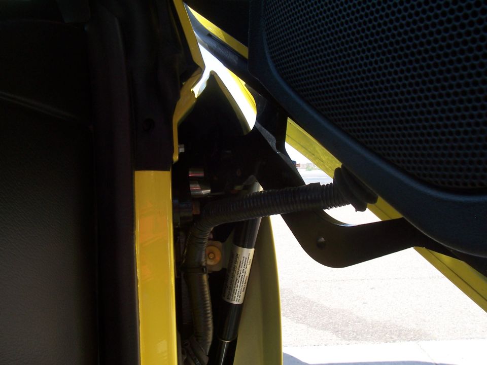 close-up of yellow car door hinge and wiring harness
