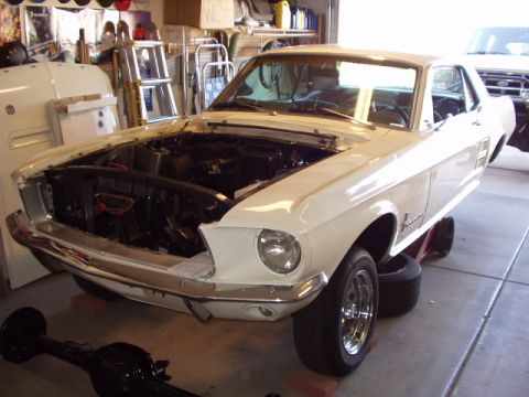 1967 Ford Mustang - Front view of a 1967 Ford Mustang undergoing maintenance in a garage.