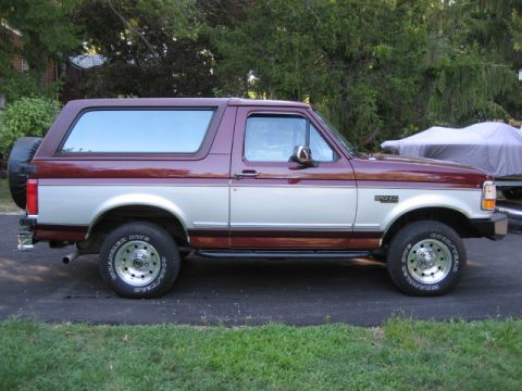 1996 Ford Bronco - Side view of a two-tone 1996 Ford Bronco parked on a driveway.