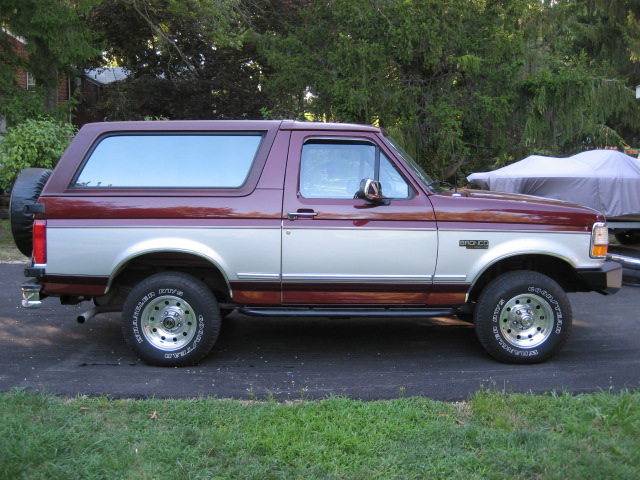 1996 Ford Bronco side profile, two-tone maroon and silver paint, spare tire on rear door