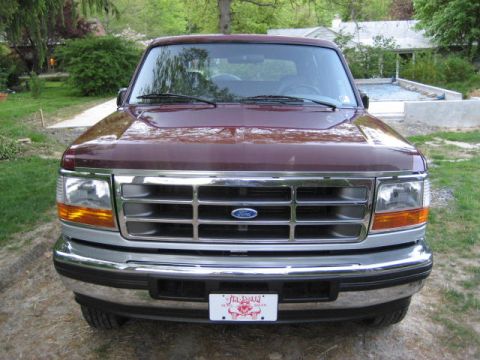 1996 Ford Bronco - Front view of a maroon Ford Bronco with a chrome grille and bumper.