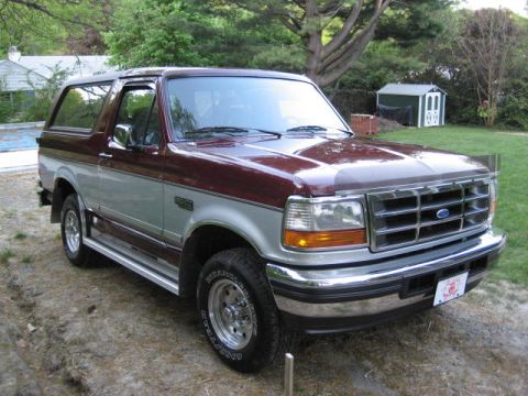 1996 Ford Bronco - This 1996 Ford Bronco features a two-tone maroon and silver paint scheme and is shown from a three-quarter front perspective.