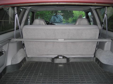 1996 Ford Bronco - The cargo space and rear seating area of an SUV are visible, looking forward from the tailgate.
