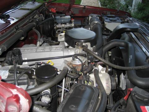 1996 Ford Bronco - Close-up view of the engine bay in a 1996 Ford Bronco, showing the V8 engine components and a red fluid reservoir.