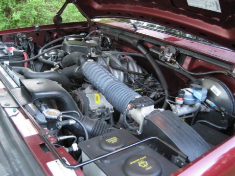 1996 Ford Bronco - Close-up view of the engine compartment, highlighting various mechanical components and wiring.