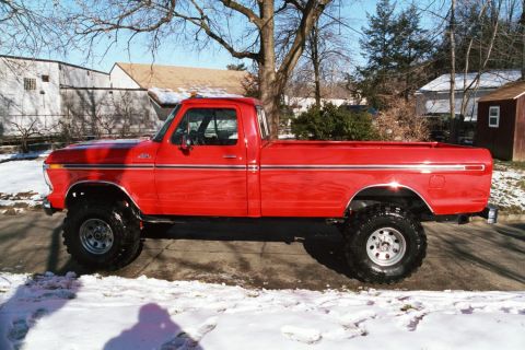 1979 Ford F-250 - This lifted red pickup truck is shown from the side on a street with snow on the ground.