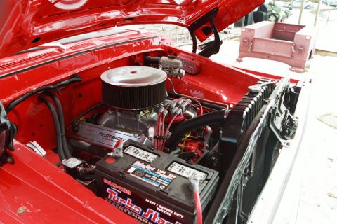 1979 Ford F-250 - The engine bay of a red 1979 Ford F-250 shows a V8 engine with a chrome air cleaner and a Turbo Start battery.