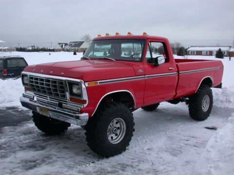 1979 Ford F-250 - Red 1979 Ford F-250 pickup truck with large tires and cab lights sits in the snow.