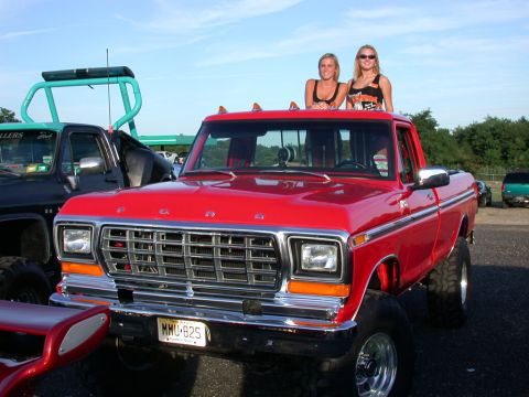 1979 Ford F-250 - This red 1979 Ford F-250 pickup truck is shown from the front with two women posing on its roof.