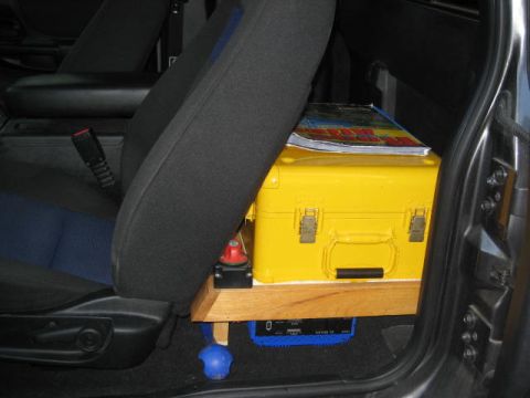 2004 Ford Ranger - The interior of a truck cab is visible, a yellow toolbox and magazines placed on a custom wooden platform.