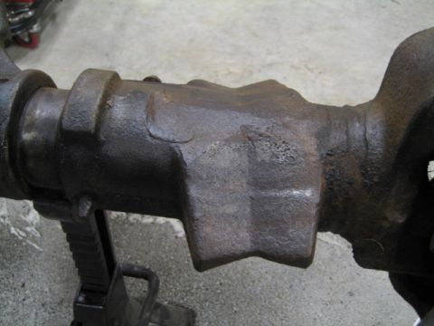 1996 Ford Bronco - This is a close-up view of a rusty differential housing, resting on jack stands in a garage.
