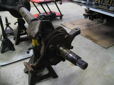 1996 Ford Bronco - A close-up view of a vehicle's front axle spindle, supported by jack stands.