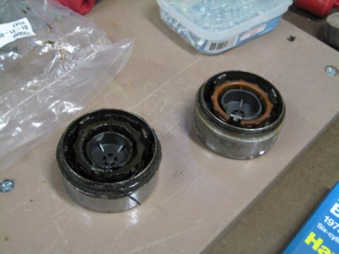1996 Ford Bronco - Two disassembled automotive components are shown on a workbench, with a plastic bag and a container of screws nearby.