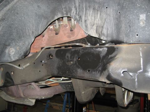 1996 Ford Bronco - Underside view of a vehicle's frame, showing suspension parts and exhaust components.