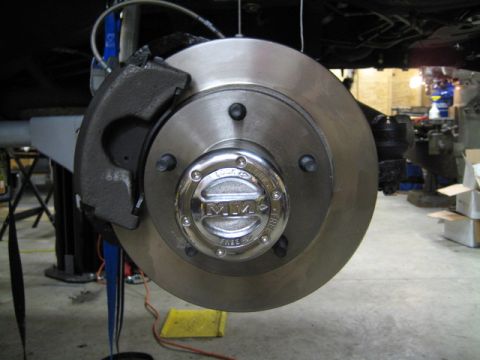 1996 Ford Bronco - Close-up of a vehicle's front wheel brake assembly with a chrome hubcap.