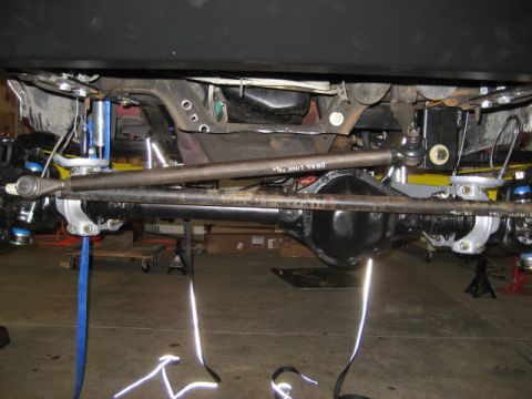 1996 Ford Bronco - The vehicle's steering linkage and front axle assembly are visible in this underside shot.