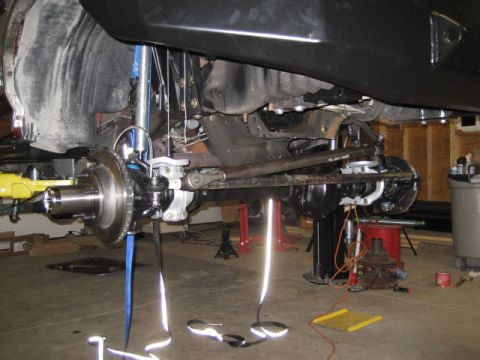 1996 Ford Bronco - Close-up view of the front suspension and undercarriage components, including the disc brake assembly and steering linkage.