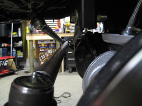 1996 Ford Bronco - Underside view of a vehicle's steering system components in a workshop setting.