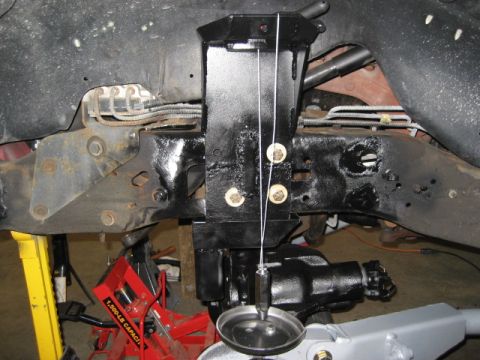 1996 Ford Bronco - Close-up view of vehicle suspension components, including a plumb bob for alignment.