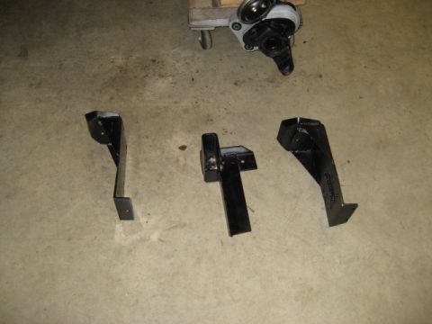 1996 Ford Bronco - Several suspension components and a differential housing are laid out on a garage floor.