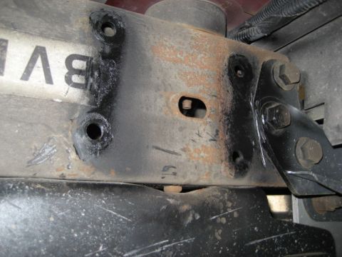 1996 Ford Bronco - A close-up view of a vehicle's frame bracket, showing signs of rust and some black paint.