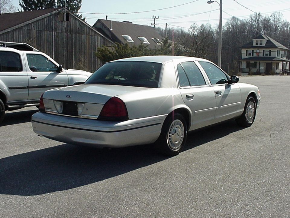 Silver 2000 Ford Crown Victoria sedan, rear 3/4 view, parked on asphalt
