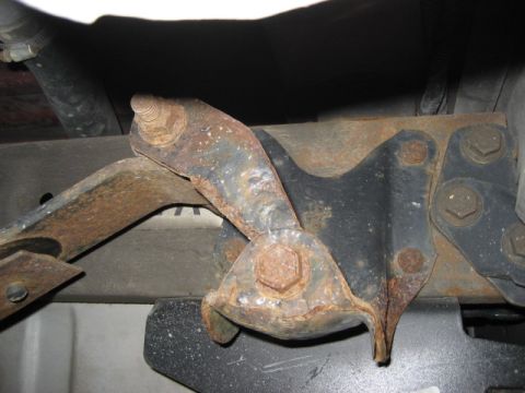1996 Ford Bronco - This image shows a close-up view of a rusted metal bracket assembly, likely from the undercarriage of a vehicle.