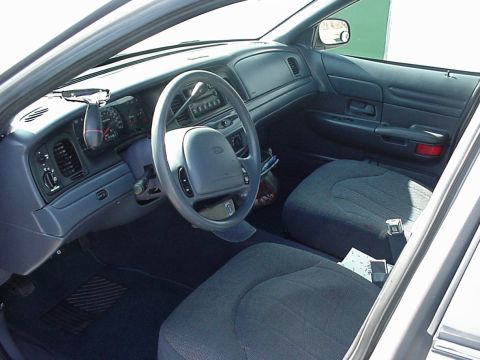 2000 Ford Crown Victoria - The interior of a 2000 Ford Crown Victoria, the dashboard, steering wheel, and front seats.