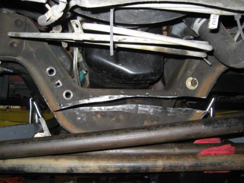 1996 Ford Bronco - Undercarriage view of vehicle suspension and frame parts, with some red rags visible.