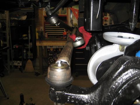 1996 Ford Bronco - Close-up view of vehicle steering and suspension parts in a garage setting.
