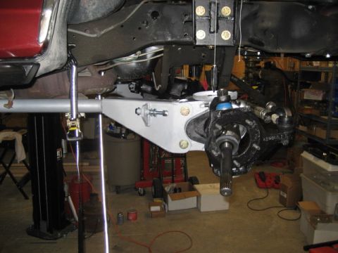 1996 Ford Bronco - The underside of a vehicle is shown, focusing on the suspension and frame, with parts laid out nearby.