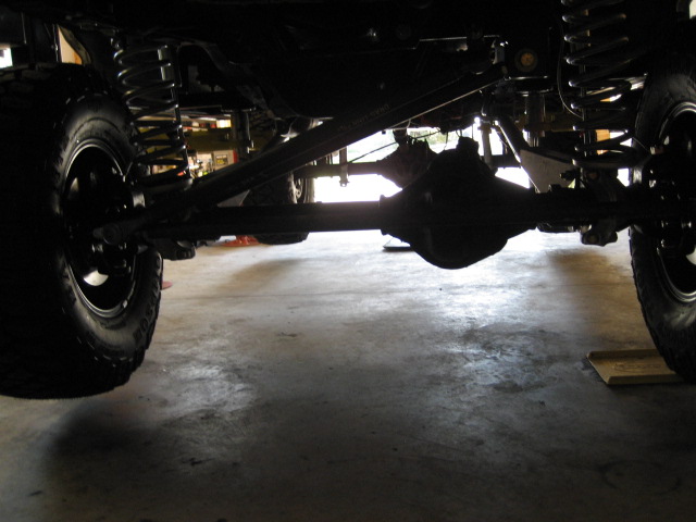 Underside view of a 4x4 vehicle's suspension and drivetrain components, including axles and springs