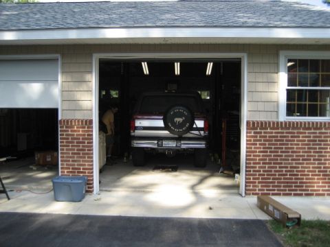 1996 Ford Bronco - A 1996 Ford Bronco is parked inside a garage, viewed from the rear with its spare tire mounted.