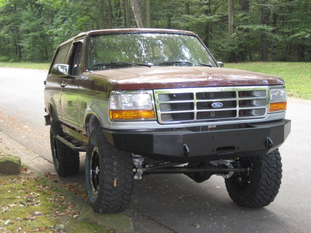 Brown and silver 1996 Ford Bronco with aftermarket bumper and large tires