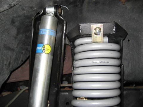 1996 Ford Bronco - Close-up of vehicle suspension parts, including a Bilstein shock and a coil spring.
