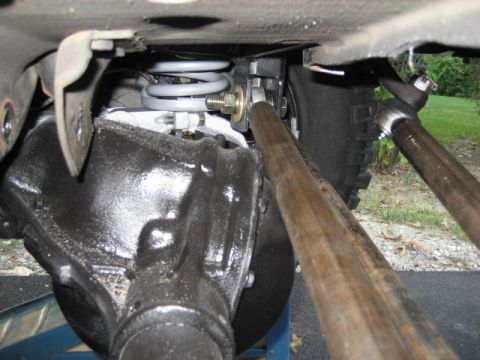 1996 Ford Bronco - Underside view of a vehicle's rear axle and suspension system, showing the differential and coil spring.