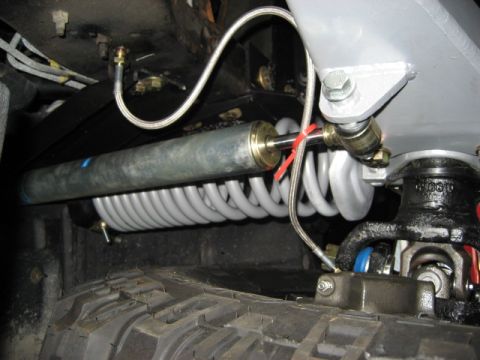 1996 Ford Bronco - Undercarriage view of a vehicle's suspension system, showing a shock absorber and coil spring.