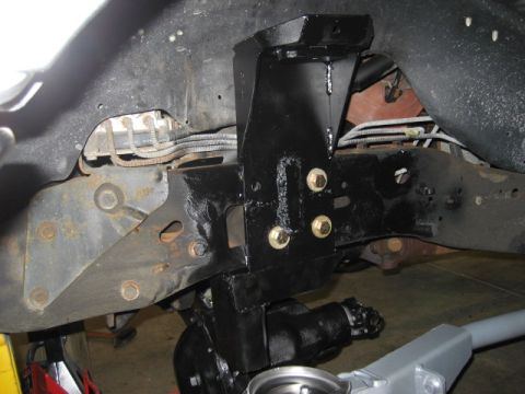 1996 Ford Bronco - Close-up view of a vehicle's undercarriage, showing suspension modifications and brake lines.