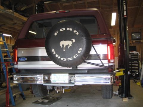 1996 Ford Bronco - Rear view of a Ford Bronco, showing its spare tire carrier and bumper, positioned on a lift.