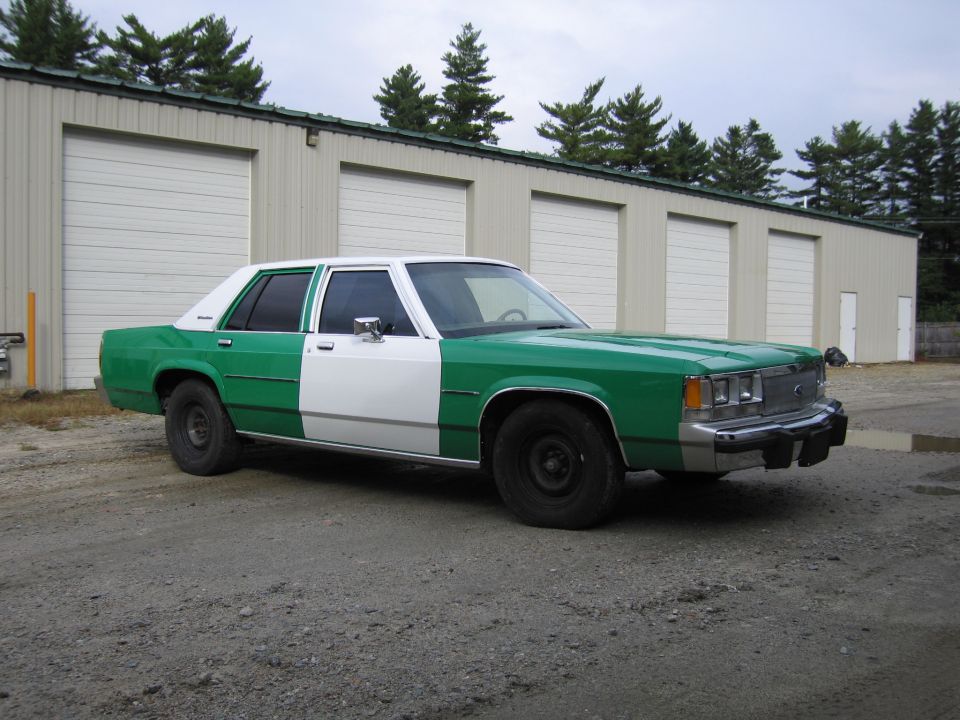 Front passenger three-quarter view of a green and white Ford sedan