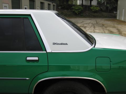 1991 Ford LTD Crown Victoria - Close-up of the rear quarter window and C-pillar of a green-and-white Ford bearing an LTD Crown Victoria badge.