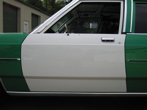 1991 Ford LTD Crown Victoria - Close-up of the white front driver door and chrome handle on a green-and-white two-tone full-size Ford sedan.