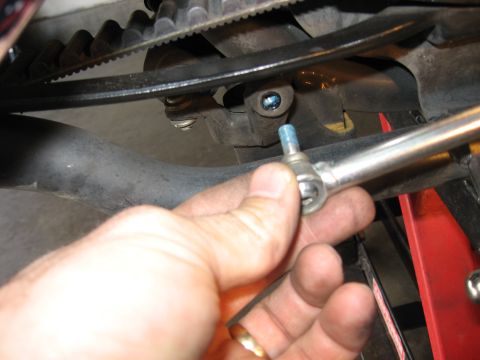 2004 Harley-Davidson Sportster Custom - Close-up of a hand working on a motorcycle's belt drive mechanism.